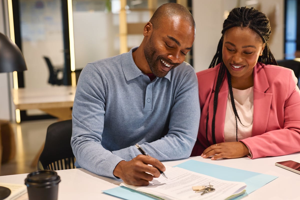 Couple signing agreement for their new home
